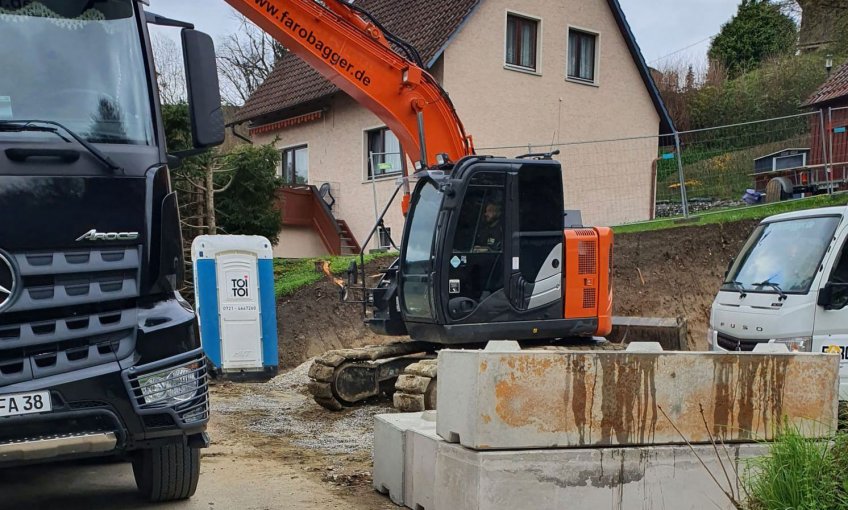 Der Bagger rollt an und die Baugrube für den Keller wird ausgehoben.